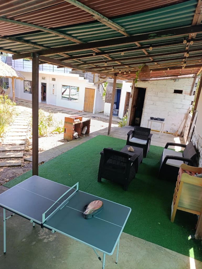 Terraza con ping-pong y lounge sobre césped artificial